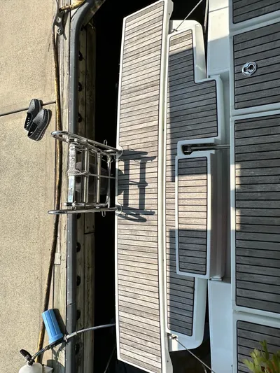 Lucky Yacht Photos Pics Beneteau Oceanis 45 yacht stern with wooden deck and ladder, docked at marina.