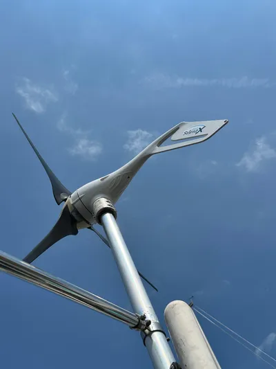 Lucky Yacht Photos Pics Wind turbine on a 2014 Beneteau Oceanis 45 sailboat against a clear blue sky.