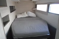 Cozy bedroom in a 2017 Leopard 45 catamaran with modern furnishings.