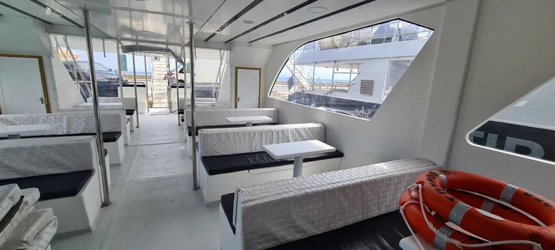  Yacht Photos Pics Interior of a 2021 Jetcraft passenger boat with seating and life rings.