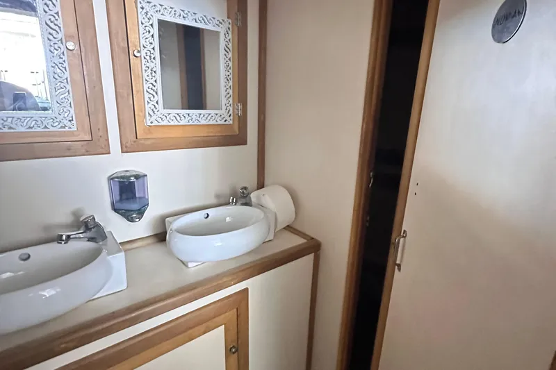  Yacht Photos Pics Elegant bathroom interior on 2021 Jetcraft passenger boat, featuring dual sinks and decorative mirrors.