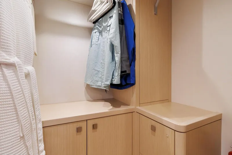 Jolly Rogers Yacht Photos Pics Sunseeker Predator 68 yacht closet with hanging clothes and wooden cabinetry, 2018 model.