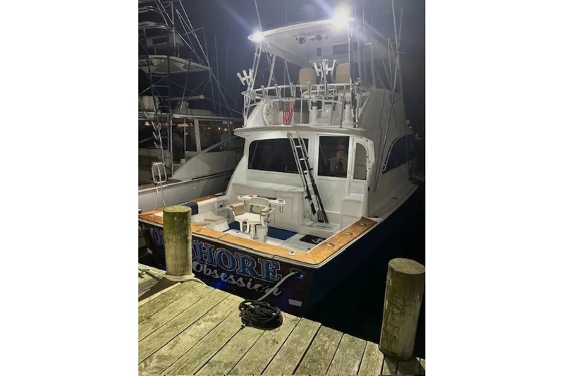 Offshore Obsession Yacht Photos Pics 1998 Ocean 53 Convertible yacht docked at night, illuminated with bright lights.