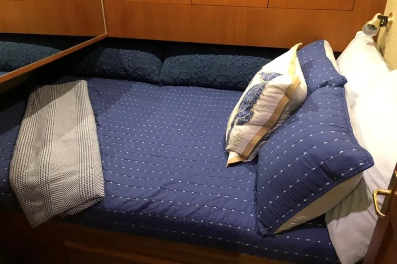 Offshore Obsession Yacht Photos Pics Cozy cabin bed with blue bedding in 1998 Ocean 53 Convertible yacht.