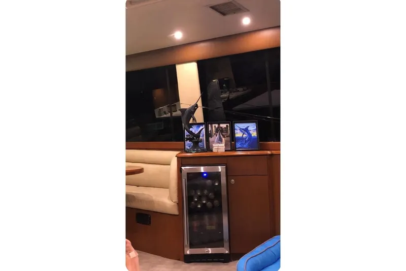 Offshore Obsession Yacht Photos Pics Interior of 1998 Ocean 53 Convertible yacht with wine cooler and framed photos.