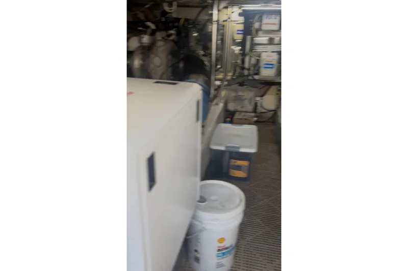 Offshore Obsession Yacht Photos Pics Engine room of a 1998 Ocean 53 Convertible yacht with storage containers and equipment.