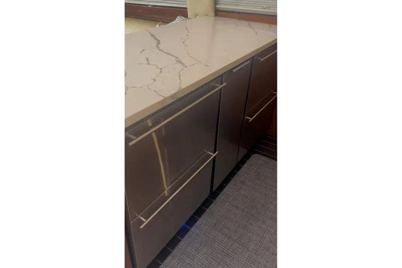 Offshore Obsession Yacht Photos Pics Modern kitchen cabinetry with sleek handles and marble countertop on Ocean 53 Convertible yacht.