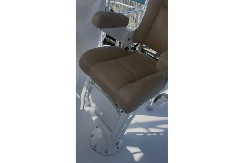 Offshore Obsession Yacht Photos Pics Captain's chair on 1998 Ocean 53 Convertible yacht, featuring tan upholstery and sturdy metal base.