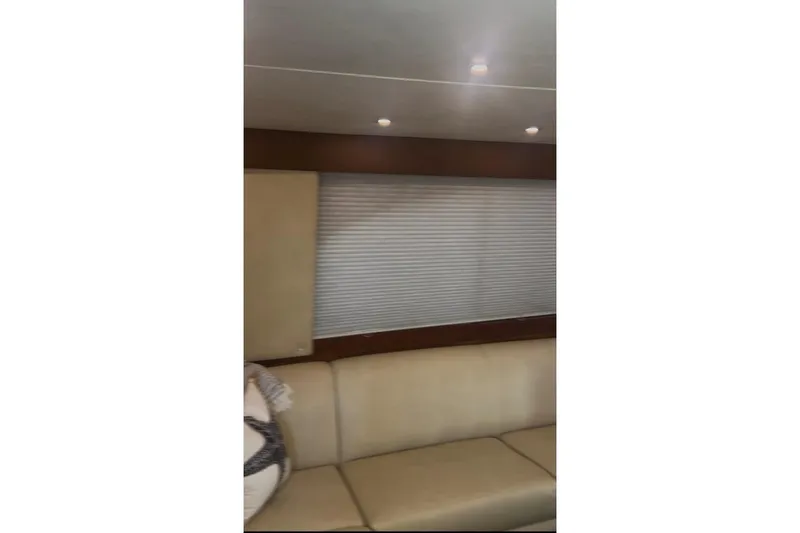 Offshore Obsession Yacht Photos Pics Interior of 1998 Ocean 53 Convertible yacht with beige seating and window blinds.