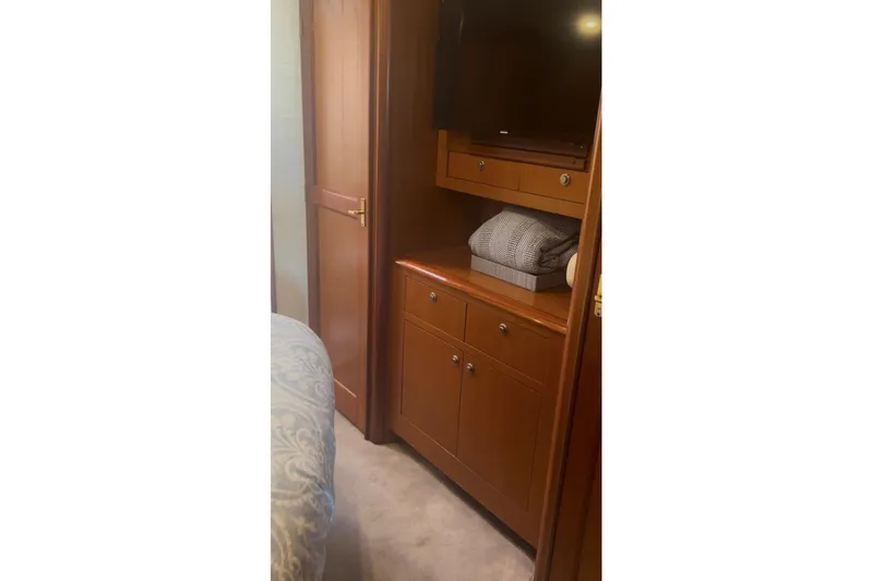Offshore Obsession Yacht Photos Pics Interior of 1998 Ocean 53 Convertible yacht with wooden cabinetry and bedding.