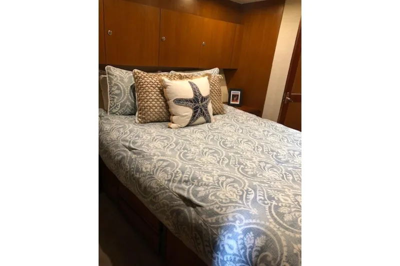 Offshore Obsession Yacht Photos Pics Cozy bedroom in 1998 Ocean 53 Convertible yacht with starfish-themed bedding.