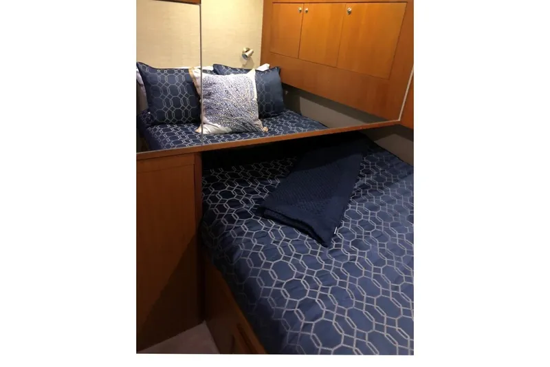 Offshore Obsession Yacht Photos Pics Cozy bedroom in 1998 Ocean 53 Convertible yacht with blue geometric bedding.