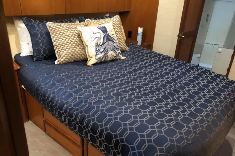 Offshore Obsession Yacht Photos Pics Luxurious bedroom interior of 1998 Ocean 53 Convertible yacht with nautical-themed bedding.