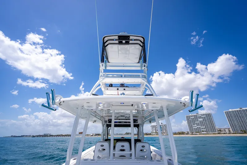  Yacht Photos Pics 2018 Everglades 435 Center Console boat on ocean, clear sky, city skyline in background.