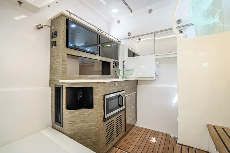  Yacht Photos Pics 2018 Everglades 435 Center Console interior with modern kitchenette and wood flooring.