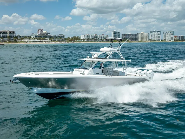  Yacht Photos Pics 2018 Everglades 435 Center Console boat cruising on ocean near city skyline.