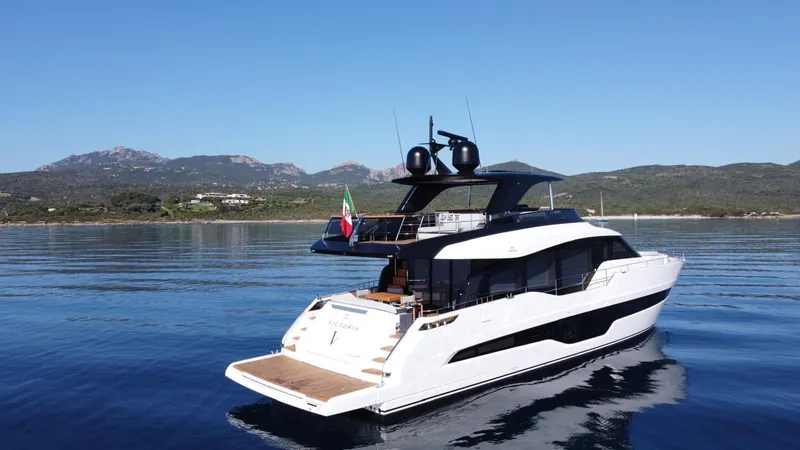 Victoria Yacht Photos Pics 2023 Cranchi Settantotto 78 yacht on calm waters with scenic mountain backdrop.