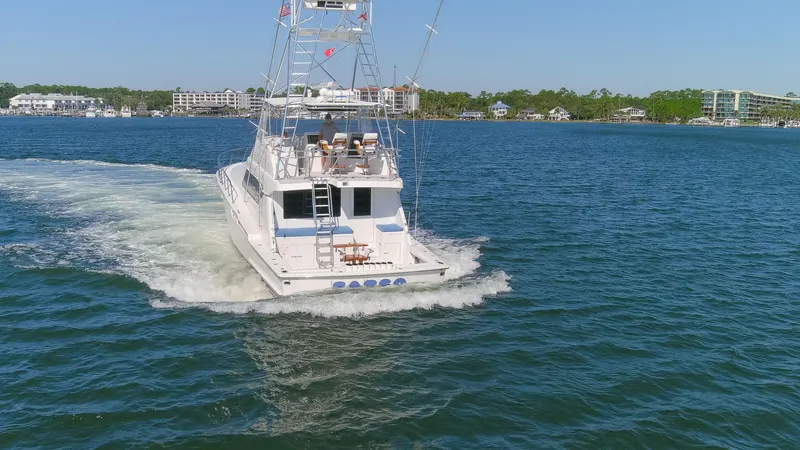 Fatso Yacht Photos Pics 1998 Hatteras 60 Convertible yacht cruising on a sunny day in open water.