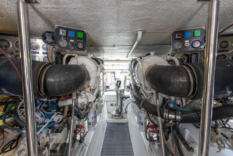 Fatso Yacht Photos Pics Engine room of 1998 Hatteras 60 Convertible yacht, showcasing dual engines and control panels.