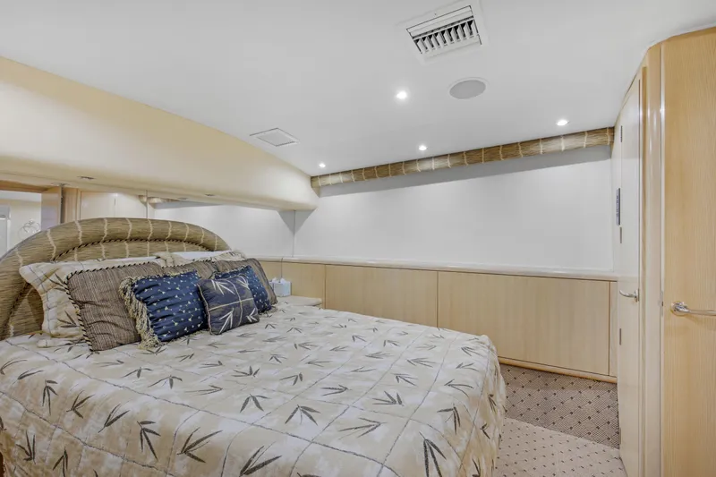 Fatso Yacht Photos Pics Luxurious bedroom interior of 1998 Hatteras 60 Convertible yacht, featuring elegant bedding and modern design.