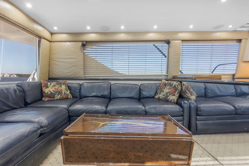Fatso Yacht Photos Pics Luxurious interior of 1998 Hatteras 60 Convertible yacht with leather seating and wooden table.
