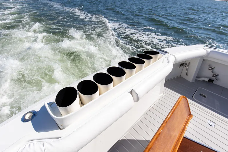 Fatso Yacht Photos Pics 1998 Hatteras 60 Convertible yacht deck with rod holders, cruising on open water.