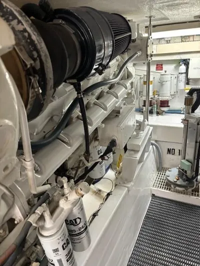 Fatso Yacht Photos Pics Engine room of 1998 Hatteras 60 Convertible yacht, showcasing mechanical components and filters.