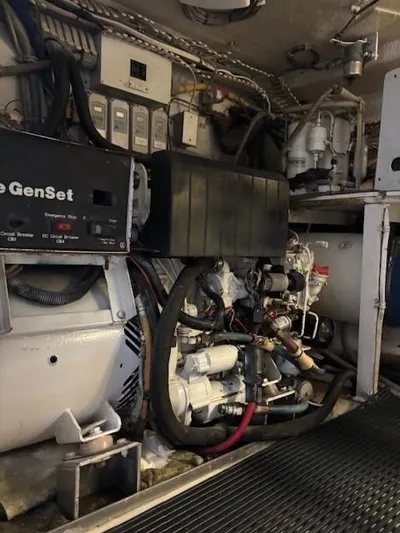 Fatso Yacht Photos Pics Engine room of a 1998 Hatteras 60 Convertible yacht, featuring a generator and mechanical components.