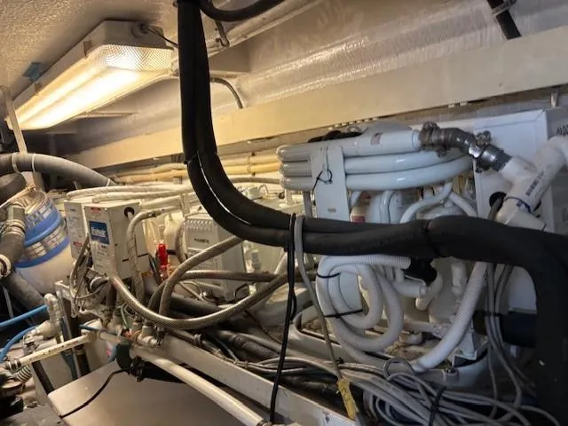 Fatso Yacht Photos Pics Engine room of 1998 Hatteras 60 Convertible yacht, showcasing complex piping and machinery.