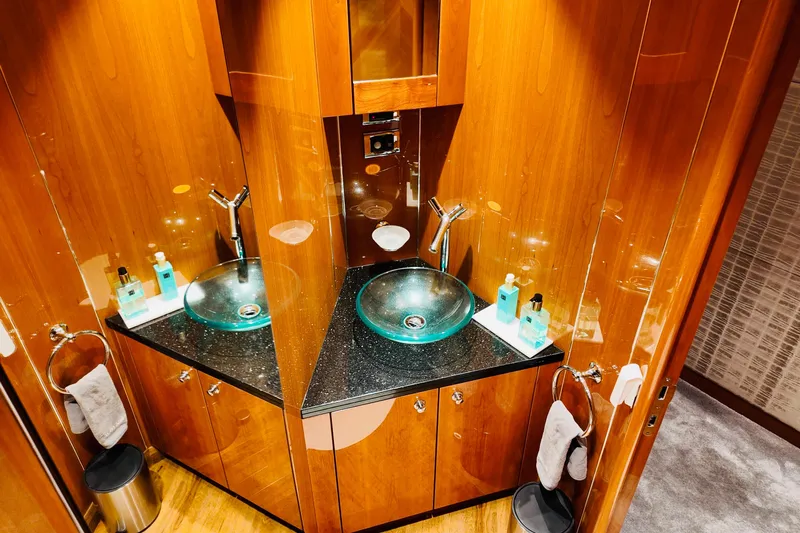 Samba Pa Ti Yacht Photos Pics Luxurious bathroom on 2004 Sunseeker 94 Yacht with glass sink and wooden cabinetry.