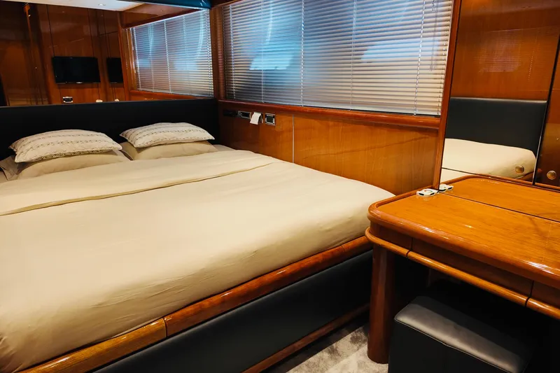 Samba Pa Ti Yacht Photos Pics Luxurious bedroom interior of 2004 Sunseeker 94 Yacht with wooden furnishings and cozy bedding.