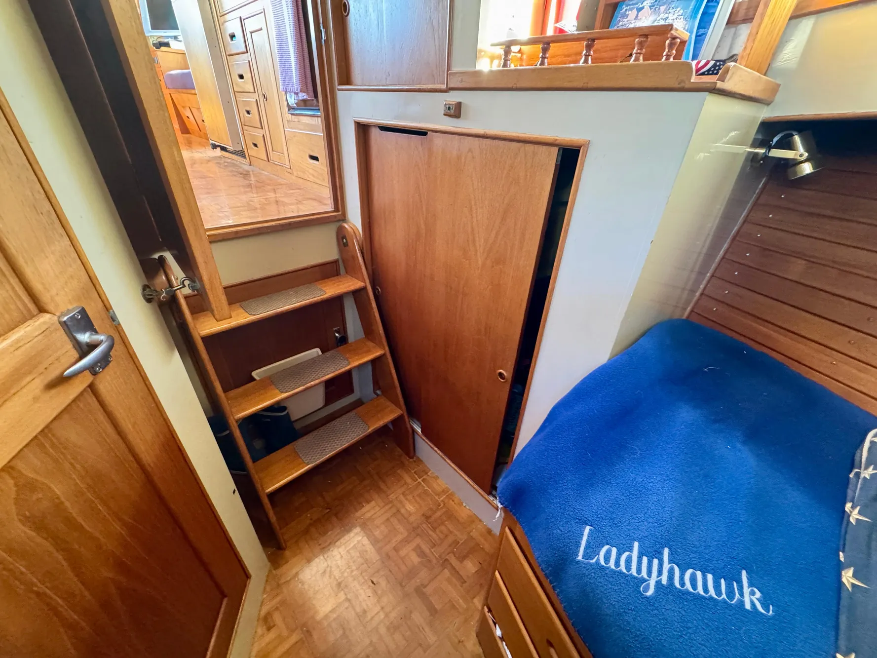 1979 Grand Banks Classic interior with wooden stairs and cozy sleeping area.