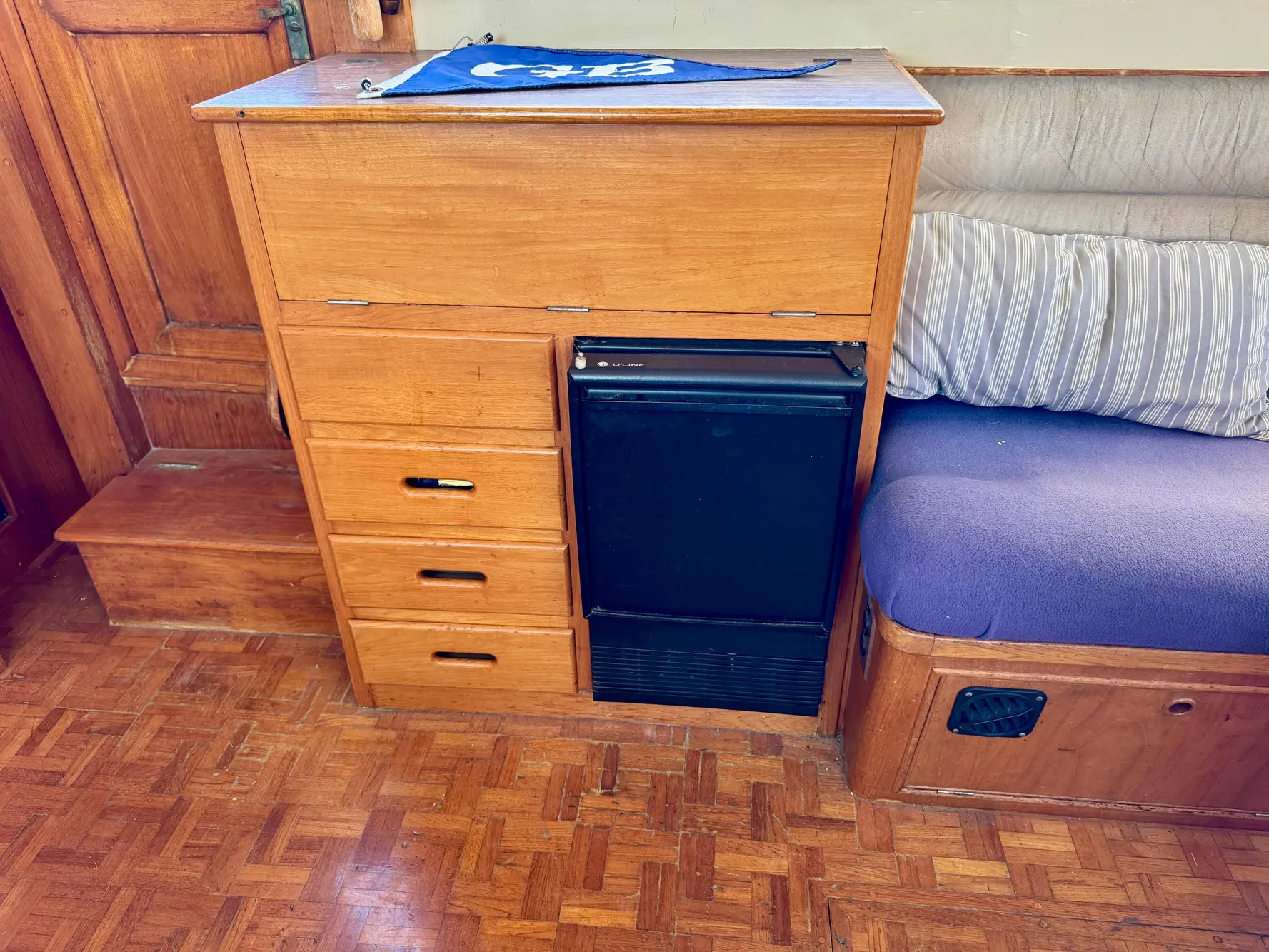 1979 Grand Banks Classic interior with wooden cabinetry and compact refrigerator.