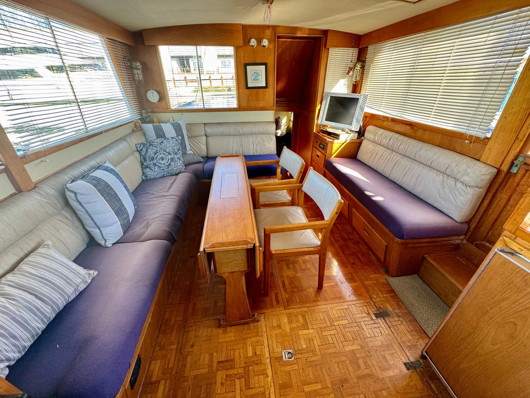 1979 Grand Banks Classic yacht interior with cozy seating and wooden furnishings.