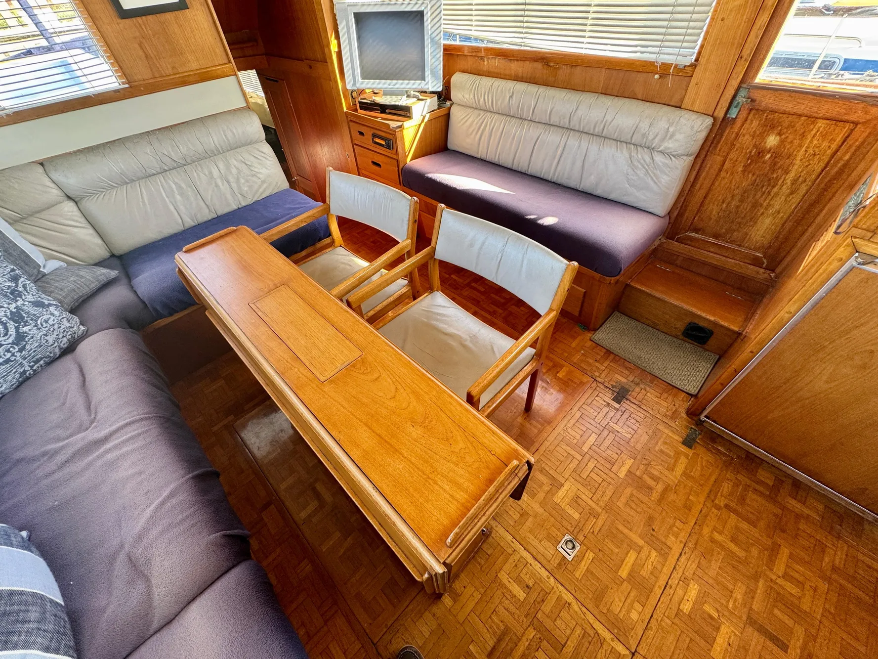 1979 Grand Banks Classic yacht interior with wooden furniture and seating area.