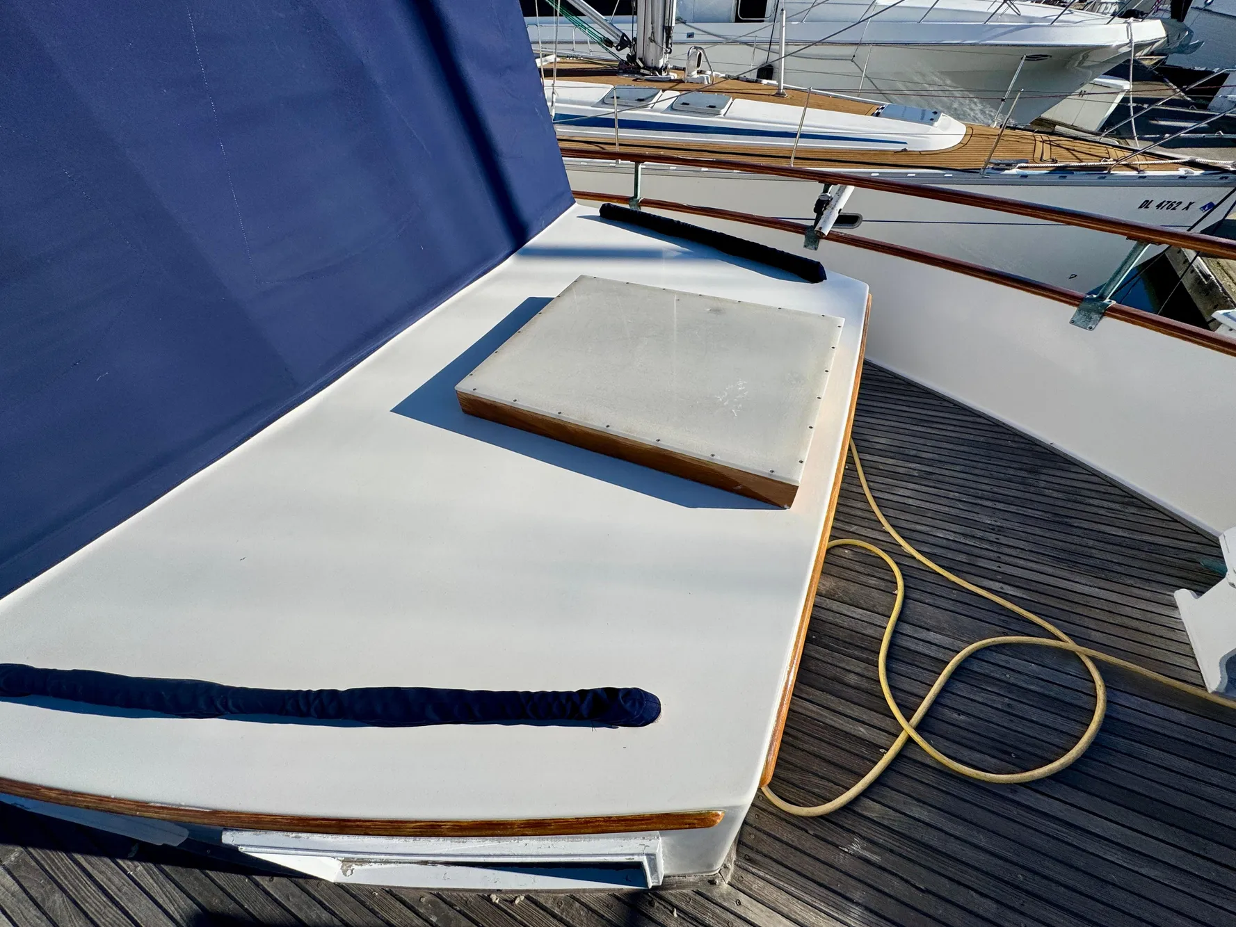 1979 Grand Banks Classic yacht deck with blue cover and wooden accents.