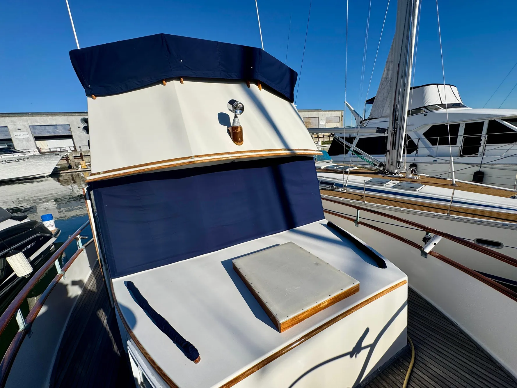 1979 Grand Banks Classic yacht with blue canvas cover, docked at marina.