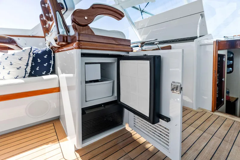 Rebel Yacht Photos Pics Rybovich Sportfish 2000 yacht interior with open mini fridge and wooden seating.