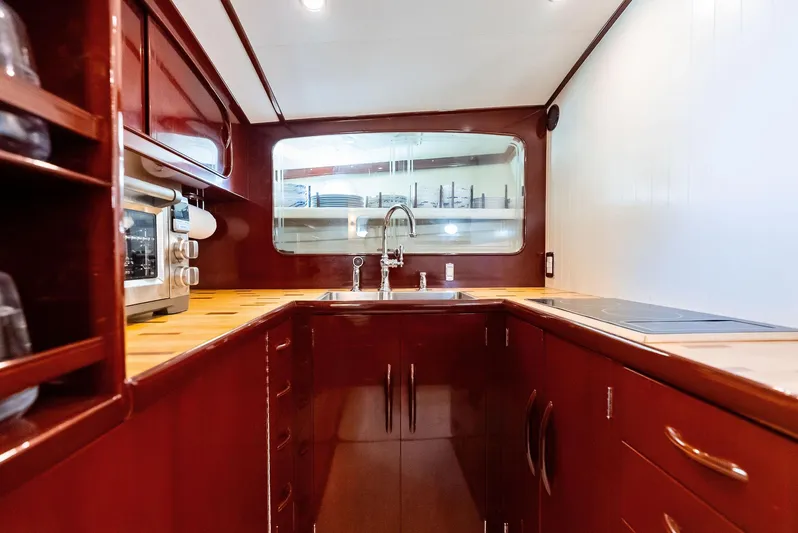 Rebel Yacht Photos Pics Luxurious galley kitchen in a 2000 Rybovich Sportfish boat, featuring rich wood cabinetry.