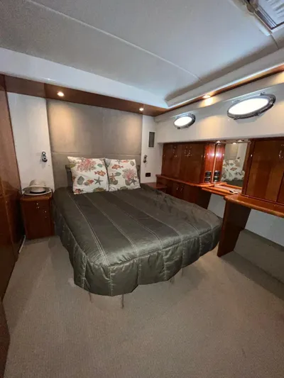 Team Yacht Photos Pics Luxurious bedroom in 2007 Maritimo M60 yacht with elegant wood finishes and cozy bedding.