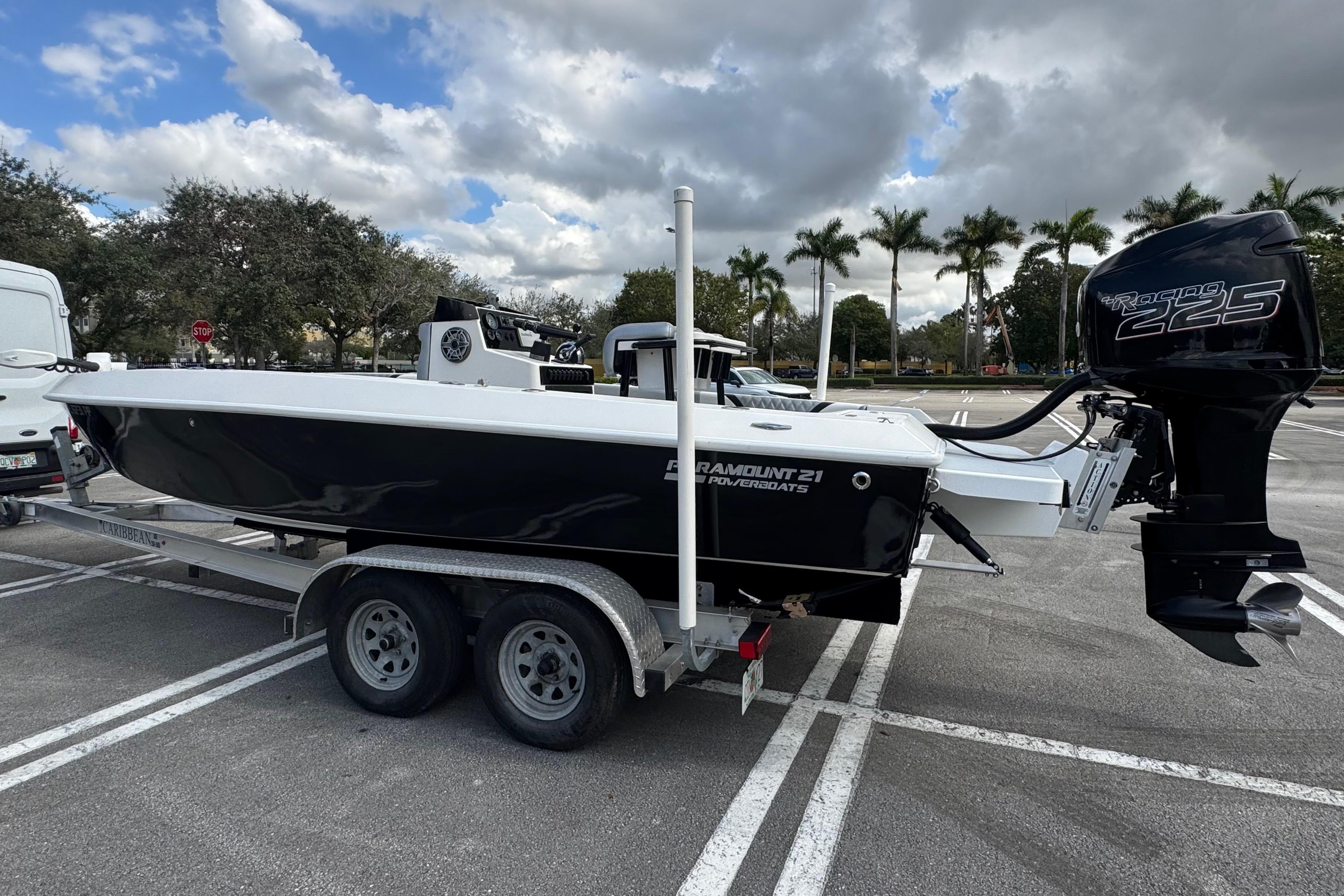 2010 Paramount Sportfisherman 21' boat on trailer, parked in lot under cloudy sky.