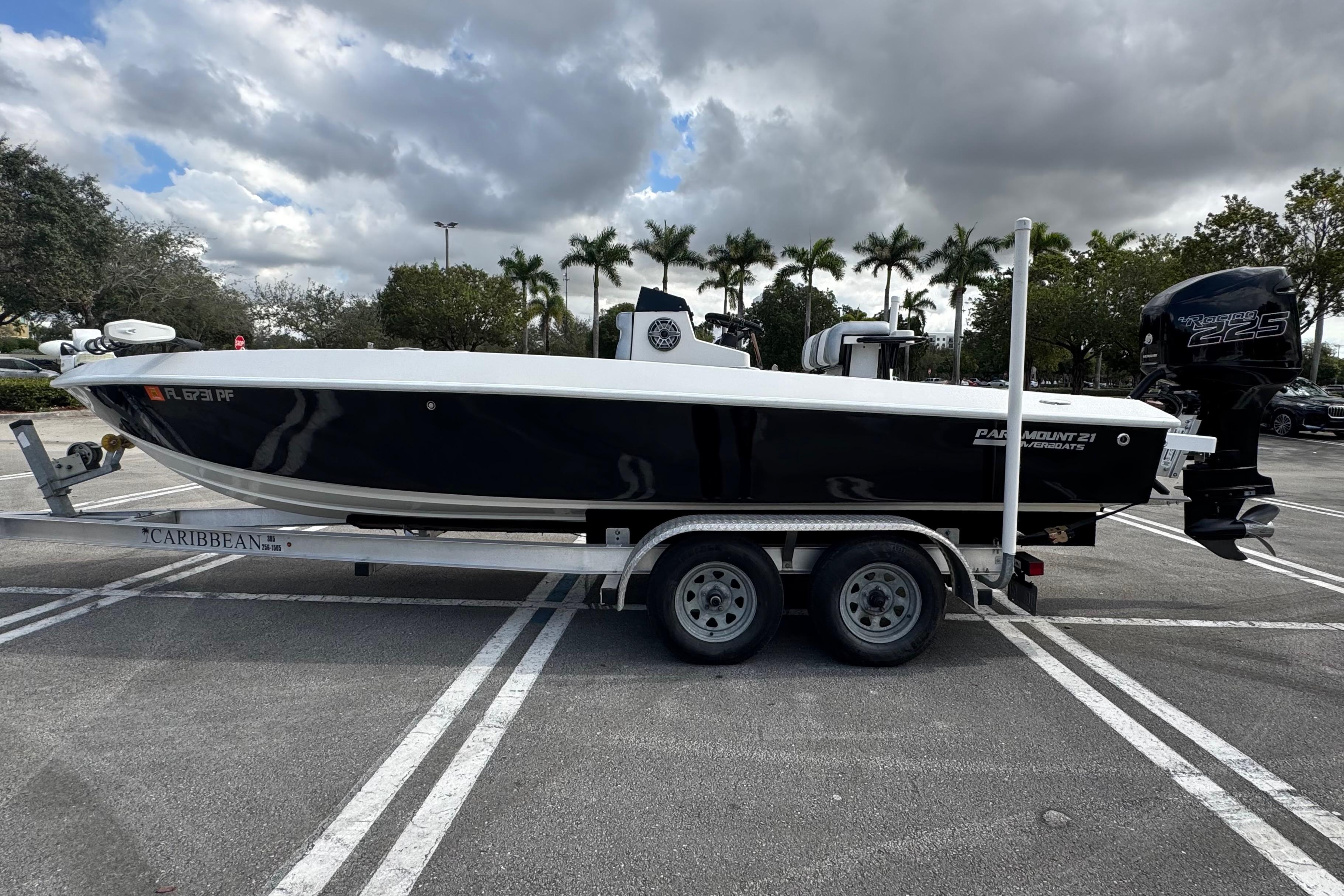 2010 Paramount Sportfisherman 21' boat on trailer in parking lot, cloudy sky background.