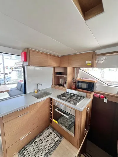 Out Of The Blue Yacht Photos Pics Modern kitchen interior of 2019 Lagoon 50 yacht with stove, sink, and microwave.