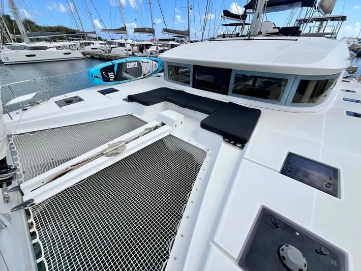 Out Of The Blue Yacht Photos Pics 2019 Lagoon 50 catamaran with spacious deck and netting, docked in a marina.