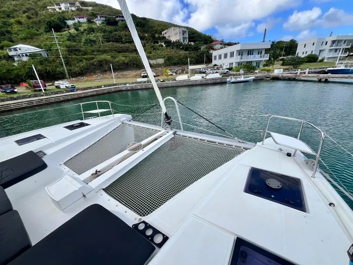 Out Of The Blue Yacht Photos Pics Lagoon 50 catamaran (2019) docked in a scenic marina with hillside and buildings.