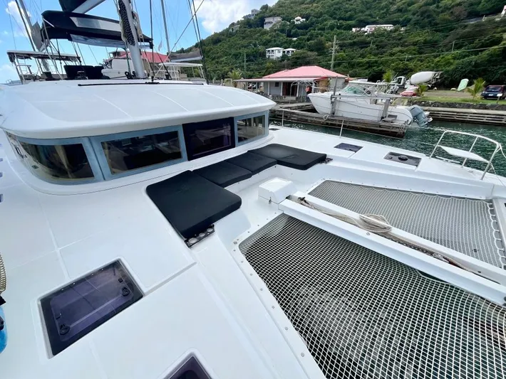 Out Of The Blue Yacht Photos Pics 2019 Lagoon 50 catamaran with spacious deck, docked in a scenic marina setting.