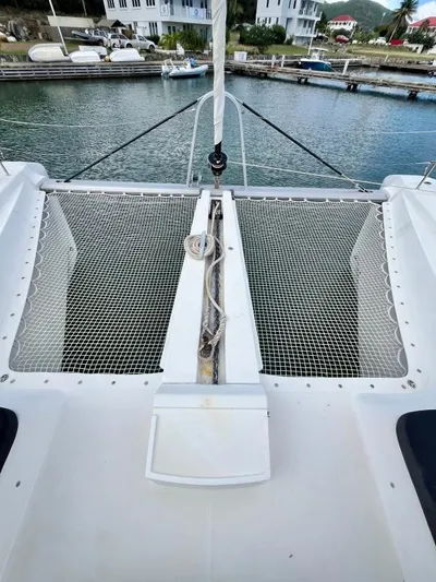 Out Of The Blue Yacht Photos Pics 2019 Lagoon 50 catamaran with netted deck, docked in a marina.