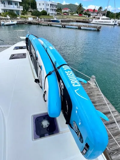 Out Of The Blue Yacht Photos Pics 2019 Lagoon 50 yacht with blue paddleboards on deck, docked in a marina.