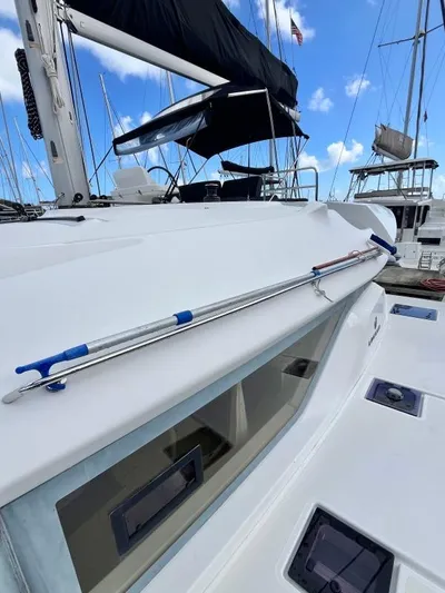 Out Of The Blue Yacht Photos Pics 2019 Lagoon 50 yacht with sleek design, docked at marina under blue sky.
