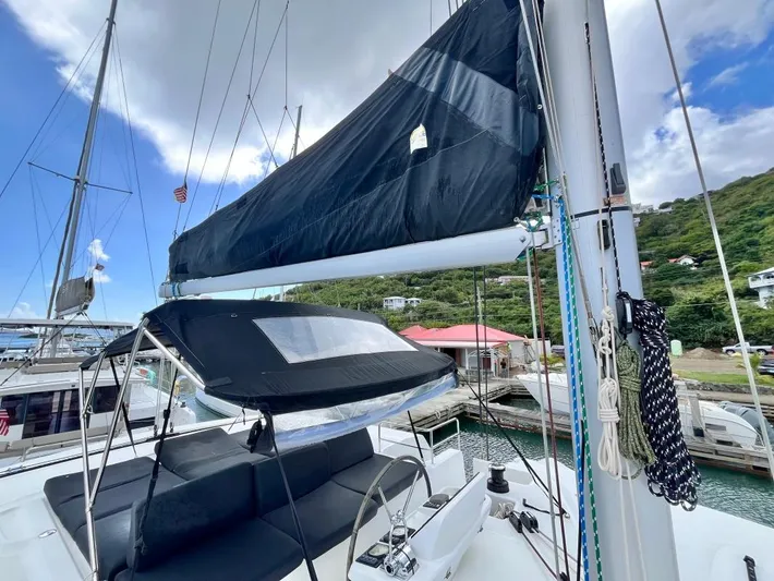 Out Of The Blue Yacht Photos Pics 2019 Lagoon 50 catamaran docked, featuring sails and cockpit under a partly cloudy sky.